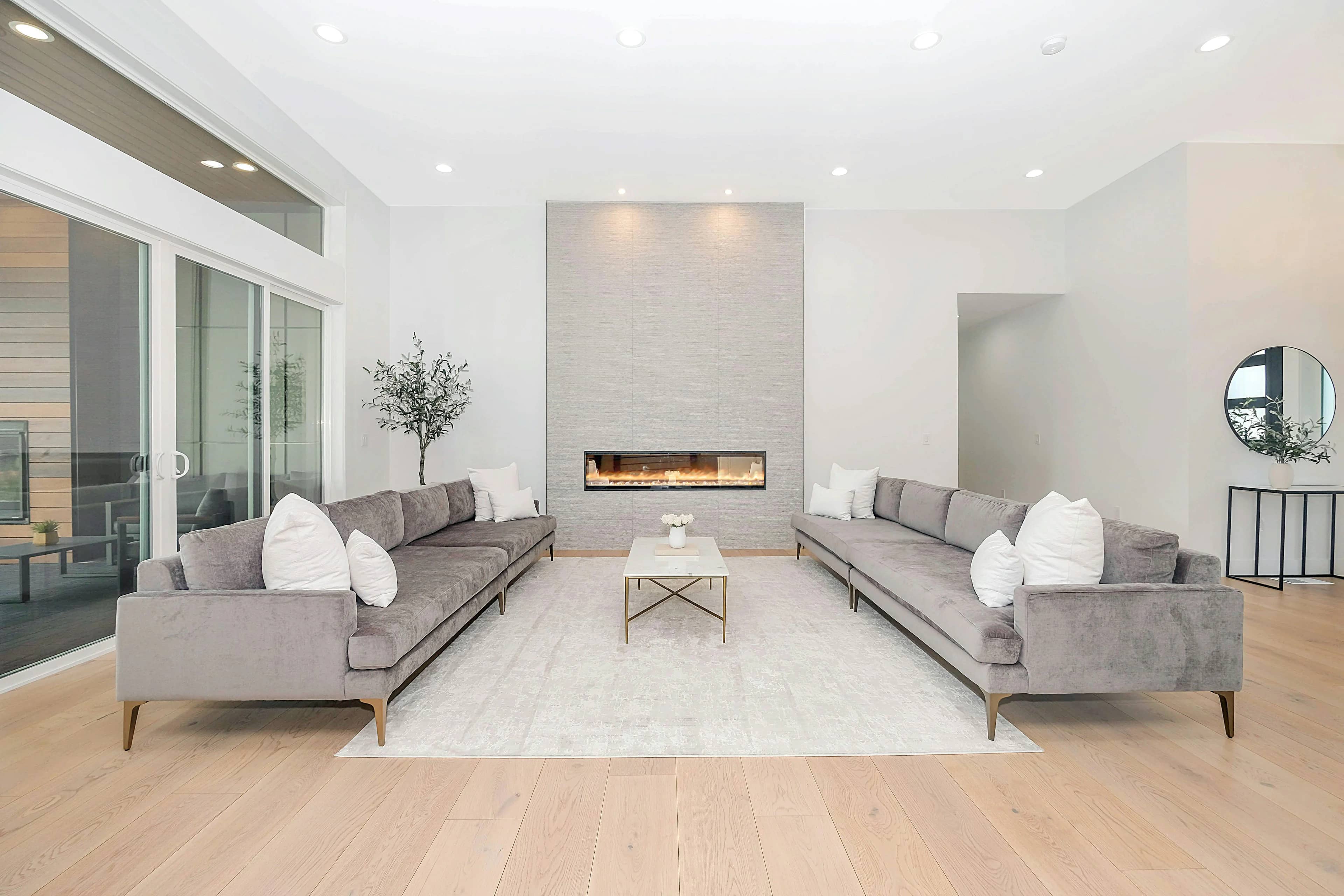Bright living room with two sofas facing a modern fireplace